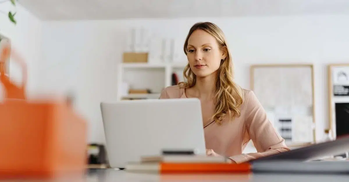 Woman at computer reading about how to adapt to business changes during COVID-19.